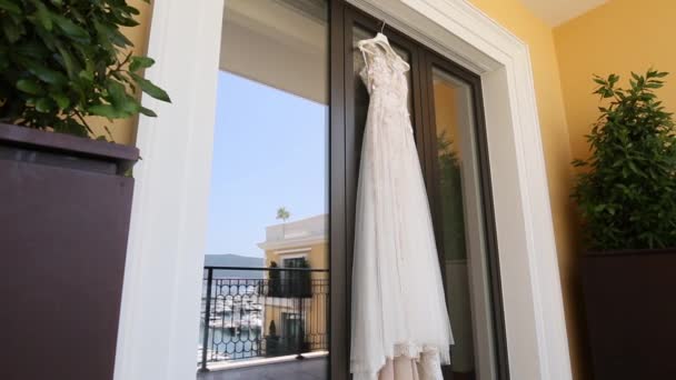 Svatební šaty nevěsty šaty visí na okně, ve kter ém