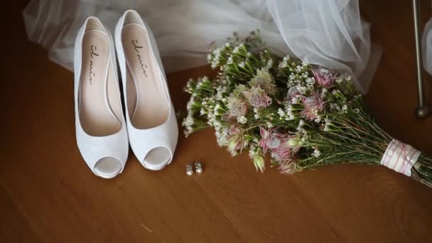 Boda zapatos de novia en un fondo de ramo de novia . — Vídeos de Stock