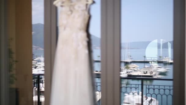 Suknia, którą oblubienica sukienka wisi w oknie, w którym th — Wideo stockowe