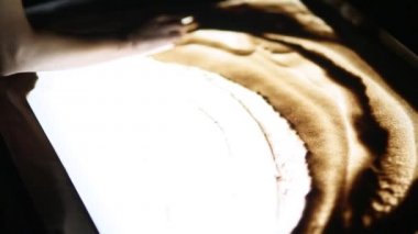 Kum ile çizim. Kısa gösteri. Kum üzerinde beyaz bir ekrana çizme. S