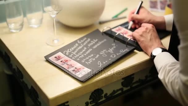 Wish book at wedding. Guests leave their wishes in book. — Stock Video