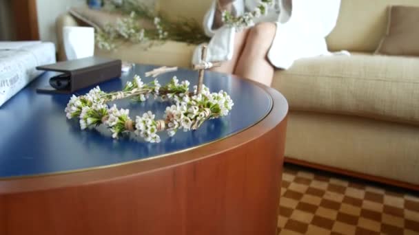 Wreath of small white flowers on the table. Wedding crown of the — Stock Video