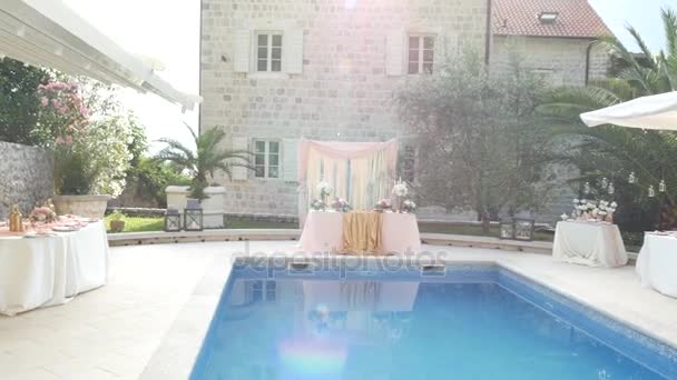 Een tabel op de bruiloft in de buurt van het zwembad. Bruiloft decoratie — Stockvideo