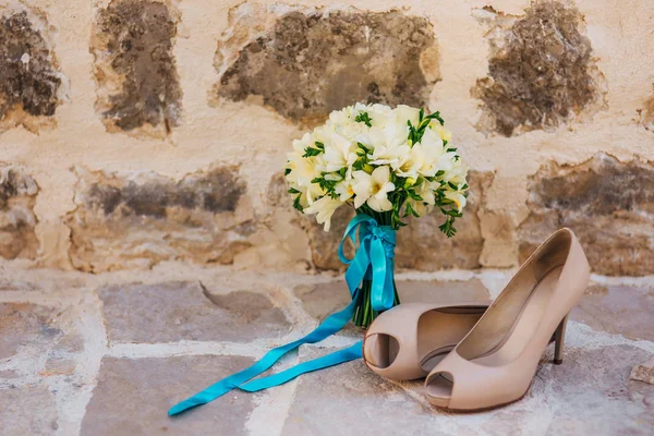 Los zapatos de boda de la novia y el ramo de la novia de las flores blancas —  Fotos de Stock