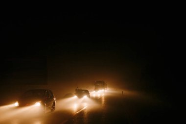 Dumanda trafik sıkışıklığı. Araba farları alevler içinde yanıyor