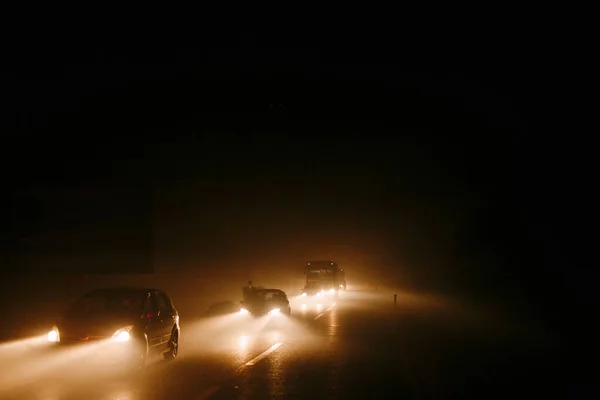 Ruch uliczny w dymie. Światło reflektorów samochodowych w dymie z ognia — Zdjęcie stockowe