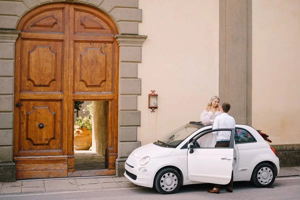 Hermosa novia de pie en un convertible y de la mano con el novio en Medici Villa de Lilliano Wine Estate, Toscana, Italia . — Foto de Stock