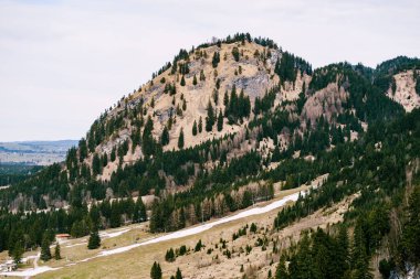 Dağlardaki yeşil kozalaklı ormanlar ince kar tabakalarıyla