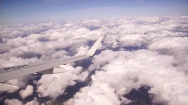 Cennetin güzel bulutları üzerinde uçuyor. Güneş tarafından hafifçe aydınlatılan yoğun kabarık bulutların resimli manzarası. Bulutların üzerinde uçarak. Bir uçak penceresinden bak.