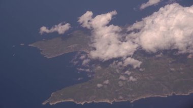 Uçaktan Hırvatistan 'daki Vis Adası' na bakın. Mavi gökyüzündeki güzel beyaz bulut bulutlarının havadan görünüşü. Pencereden gelen bir uçağın kanadı. Seyahat kavramı