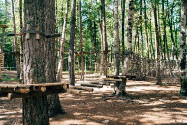 Ağaçların tepesindeki parka tırmanmak. Lunaparkta engel parkı. Açık hava sporları aktivitesi. Macera tekli spor yarışması. Ormanda yüksek ip elementleri.