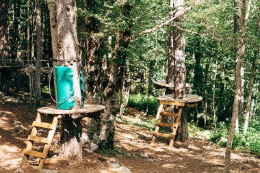 Ağaçların tepesindeki parka tırmanmak. Lunaparkta engel parkı. Açık hava sporları aktivitesi. Macera tekli spor yarışması. Ormanda yüksek ip elementleri.