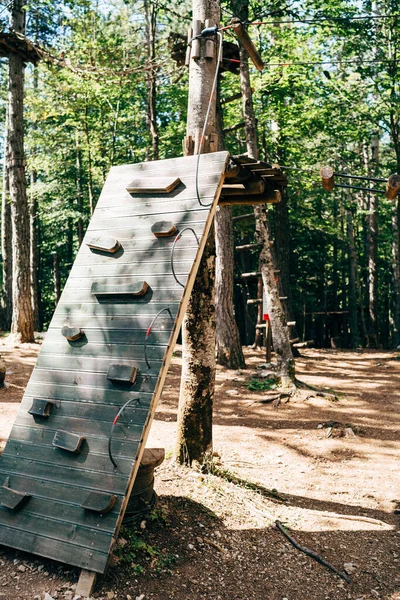 Park wspinaczkowy wysoko na drzewach. Bieg przeszkód w wesołym miasteczku. Zajęcia sportowe na świeżym powietrzu. Wyzwanie przygoda sport solowy. Element wysokich lin w lesie. — Zdjęcie stockowe