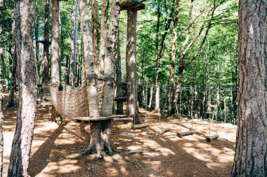 Ağaçların tepesindeki parka tırmanmak. Lunaparkta engel parkı. Açık hava sporları aktivitesi. Macera tekli spor yarışması. Ormanda yüksek ip elementleri.