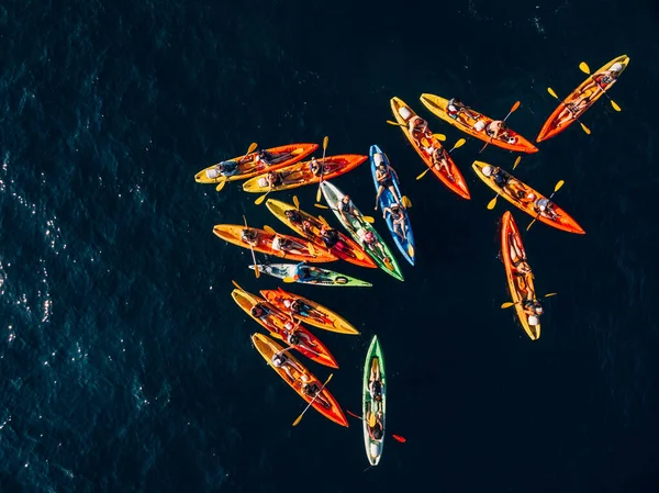 Un grupo de kayakistas reunieron sus kayaks en un montón en el mar. Grupo de natación en pares de kayaks. Viaje de bandera conceptual. Vista superior aérea . — Foto de Stock