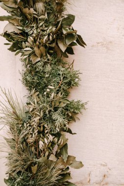 Zeytin, palmiye, kozalaklı, defne yapraklı ve thuja dalları bir bohçaya örülmüş. Hırvatistan 'ın Dubrovnik kentinde yeni yıl için evin girişini süsleyen Noel geleneği