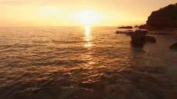 モンテネグロのアドリア海に沈む黄色の夕日。太陽は海に沈み、空全体を黄色で塗ります。海の光の波、水の質感に日当たりの良いパスで — ストック動画