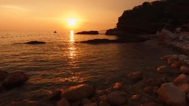 モンテネグロのアドリア海に沈む黄色の夕日。太陽は海に沈み、空全体を黄色で塗ります。海の光の波、水の質感に日当たりの良いパスで — ストック動画