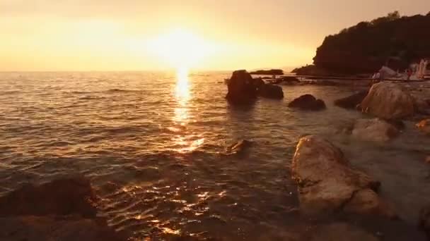 モンテネグロのアドリア海に沈む黄色の夕日。太陽は海に沈み、空全体を黄色で塗ります。海の光の波、水の質感に日当たりの良いパスで — ストック動画