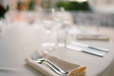 Düğün yemeği masasının yakın çekimi. Düğün masasına servis yapmak. Çatallar peçeteye konur..