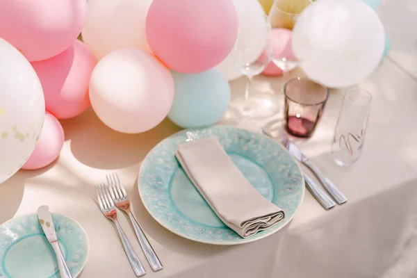 Réception de table de mariage. Assiettes bleues avec un motif et une serviette, sur une nappe crème. Des petits ballons sur la table. Servir une table pour un enterrement de vie de jeune fille . — Photo