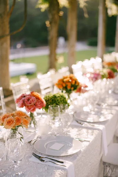 Resepsi meja makan malam pernikahan. Lihat dari atas pada piring bulat putih close-up. Bouquets of pink, orange, green flowers. Mawar merah muda, mawar oranye kecil. Tampilan atas — Stok Foto
