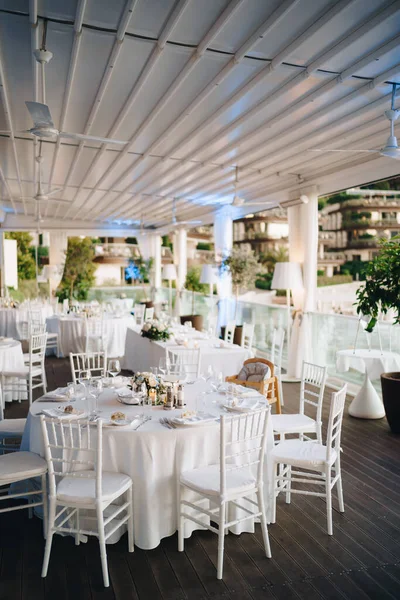 Mesa de jantar de casamento recepção. Mesa de banquete redonda com toalha de mesa branca e cadeiras Chiavari brancas. Casamento sob a tenda . — Fotografia de Stock