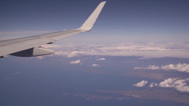 乗客用飛行機の玄関からの眺め。飛行機は厚い雲の上を飛ぶ、カメラは翼を示す、旅行と豊かな生活の概念 — ストック動画