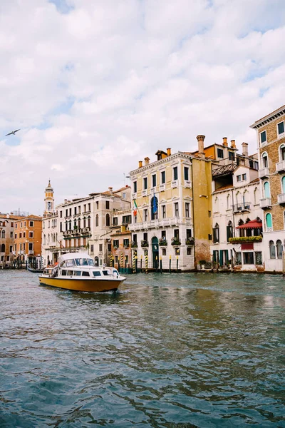 Turistas en el paseo marítimo de Venecia, sobre el fondo de las antiguas fachadas de los edificios de pie en el agua. Turismo acuático en Venecia, Italia . — Foto de Stock