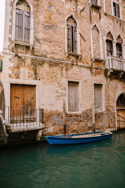 Barcos amarrados en las paredes de un edificio en un canal en Venecia, Italia. Clásicas vistas a la calle veneciana - persianas de madera, casas de ladrillo, puentes — Foto de Stock