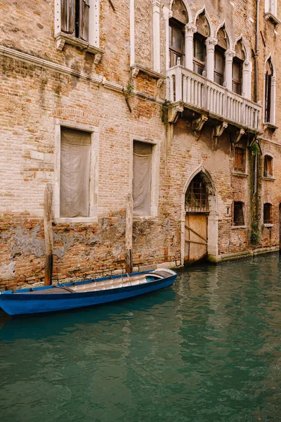 Човни пришвартувалися біля стін будинку в каналі у Венеції, Італія. Класичні венеціанські вулиці: дерев'яні віконниці, цегляні будинки, мости. — стокове фото