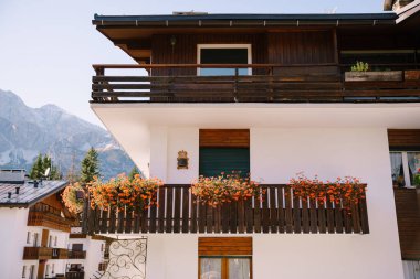 Kuzey İtalya 'da, Dolomitler' de ahşap elementlerle bembeyaz bir ev. Cortina Ampezzo kasabasındaki bir kış kayak merkezinde..