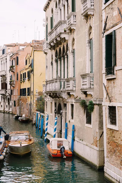 Човни пришвартувалися біля стін будинку в каналі у Венеції, Італія. Класичні венеціанські вулиці: дерев'яні віконниці, цегляні будинки, мости. — стокове фото