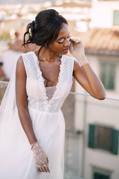 Прекрасна афро-американська наречена в білій весільній сукні, торкається її обличчя в вінтажних рукавицях. Весілля в Флоренції (Італія).. — стокове фото
