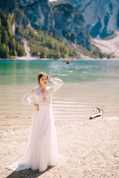 이탈리아 의 라고 디 브라이 어스 호수에 소매와 레이스 를 단 흰 키 폰 옷을 입은 아름다운 신부. 유럽의 유명 한 브레 이브스 호수에서 열리는 목적지 결혼식. — 스톡 사진