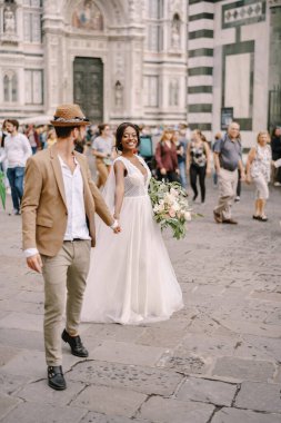 Irklar arası evlilik çifti. Düğün Floransa, İtalya 'da. Afro-Amerikalı gelin ve beyaz damat Piazza del Duomo boyunca yürüyorlar..