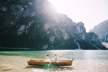 Yeni evliler İtalya 'da Lago di Braies' de tahta bir teknede yelken açarlar. Avrupa 'da düğün, Braies Gölü' nde. Düğün çifti - Damat tahta küreklerle kürek çeker, gelin tam karşısında oturur.