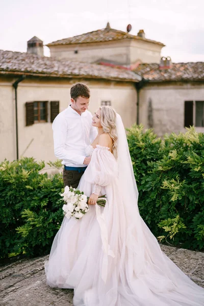 イタリアのトスカーナにある古いワイナリーのヴィラで結婚式。古いワイナリーヴィラの屋根の上に結婚式のカップル. — ストック写真