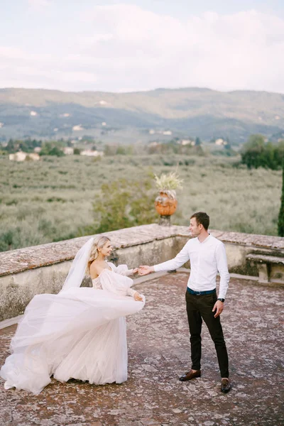 イタリアのトスカーナにある古いワイナリーのヴィラで結婚式。花嫁と新郎が別荘の屋根の上で踊っています. — ストック写真