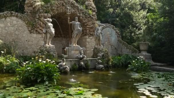 Old stone fountain in the botanical garden Trsteno, near Dubrovnik, Croatia. Statue of Neptune, goldfish in the water, blooming green water lilies. Film location Game of Thrones — Stock Video