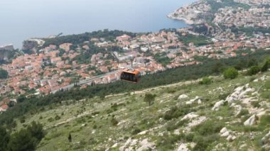 Teleferikli asansördeki turistler Hırvatistan 'ın eski Dubrovnik kentinin yukarısındaki bir dağa tırmandılar.