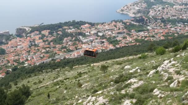 Turistas en teleférico suben a una montaña sobre el casco antiguo de Dubrovnik, Croacia . — Vídeo de stock