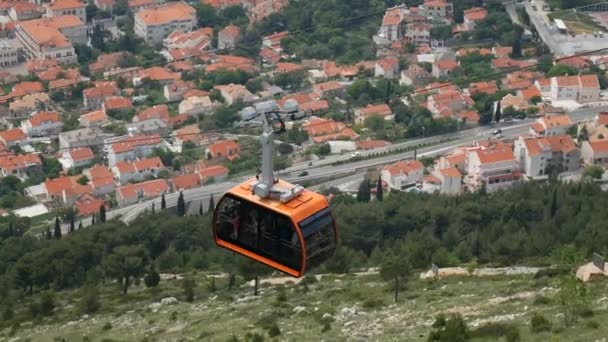Hırvatistan 'ın Dubrovnik kentinde bir teleferikle dağdan inen turistler. — Stok video