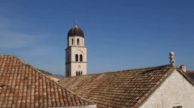 Dubrovnik 'teki Fransisken manastırının çan kulesi şehrin kiremitlerinin arka planına karşı..