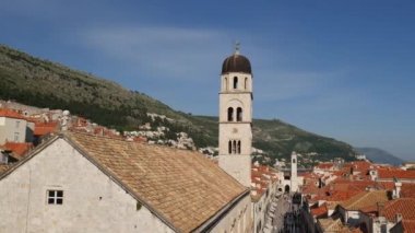 Dubrovnik 'teki Fransisken manastırının çan kulesi şehrin kiremitlerinin arka planına karşı..