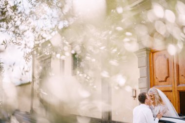Gelin kabininden dışarı bakar ve damadı öper. Floransa, İtalya 'da düğün, eski bir villa-şaraphanesinde.
