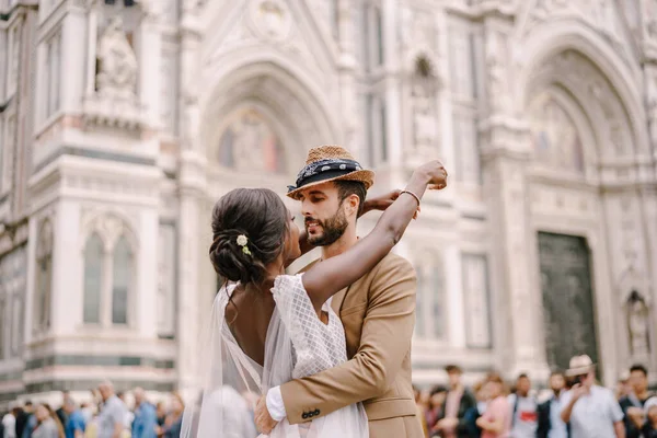 Multiraciaal echtpaar. Bruiloft in Florence, Italië. Afro-Amerikaanse bruid en Kaukasische bruidegom knuffelen op Piazza del Duomo. — Stockfoto