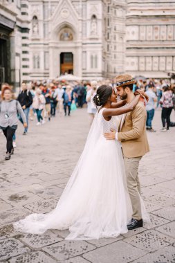 Irklar arası evlilik çifti. Düğün Floransa, İtalya 'da. Afro-Amerikalı gelin ve beyaz damat Piazza del Duomo 'da kucaklaşıyorlar..