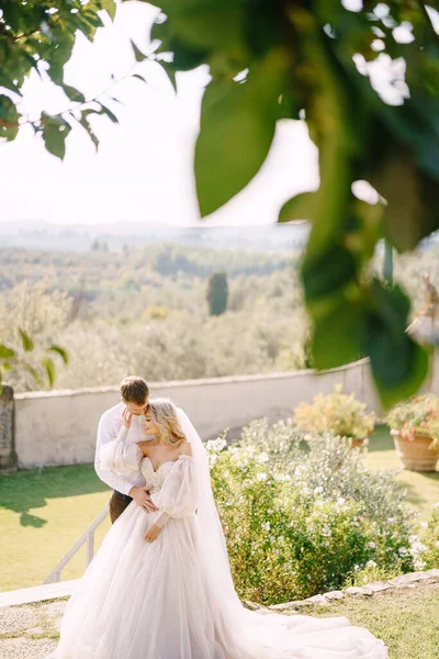 イタリアのフィレンツェで、古いヴィラワイナリーで結婚式。日没時に庭で結婚式のカップル. — ストック写真