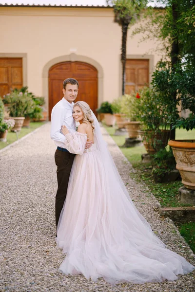 Um jovem casal está abraçando e olhando para a câmera. Casamento em Florença, Itália, em uma antiga vinícola . — Fotografia de Stock